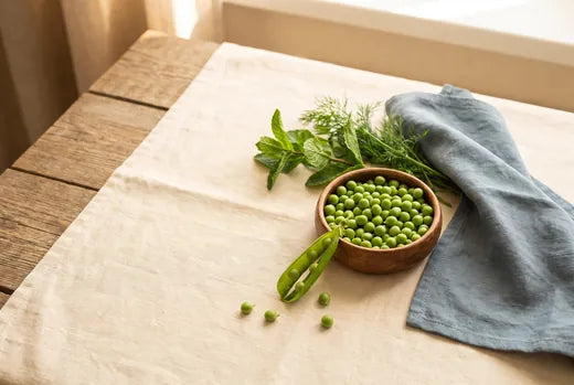Fresh green peas and herbs in a rustic kitchen flat lay
